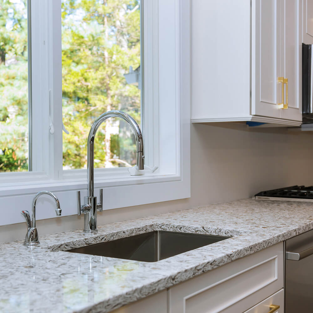 White marble kitchen countertop with window view and plants